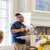 Dr. Shorty standing at podium addressing crowd.